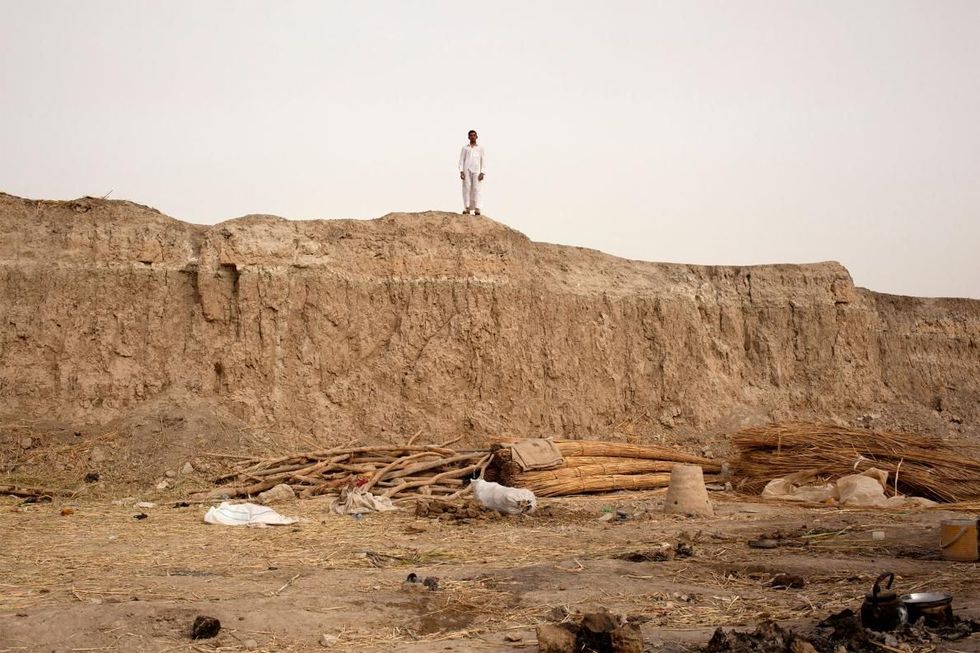 Een man staat op een voormalig wetland in het zuiden van Irak De wilde fauna die hier is verdwenen nadat de moerassen zijn drooggelegd herstelt zich zeer langzaam