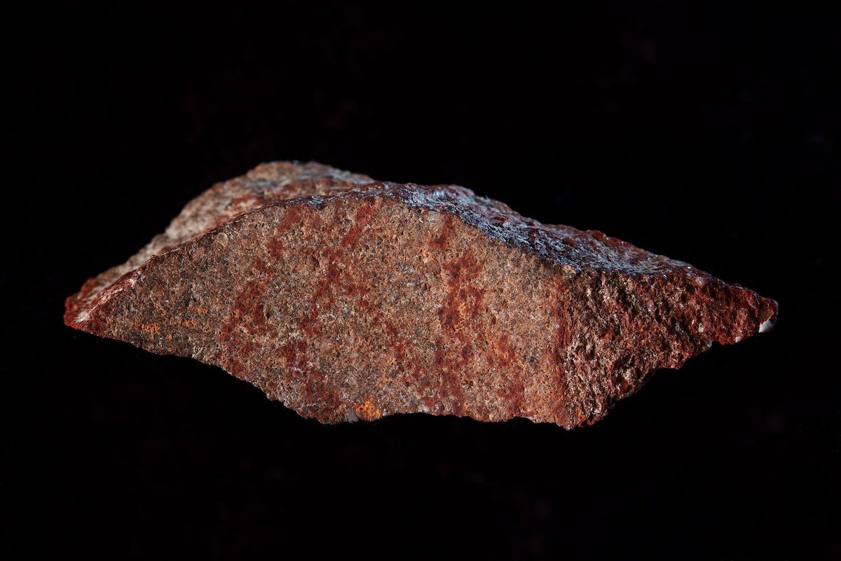 Dit stuk steen gemarkeerd met oker werd gevonden in de Blombosgrot in ZuidAfrika
