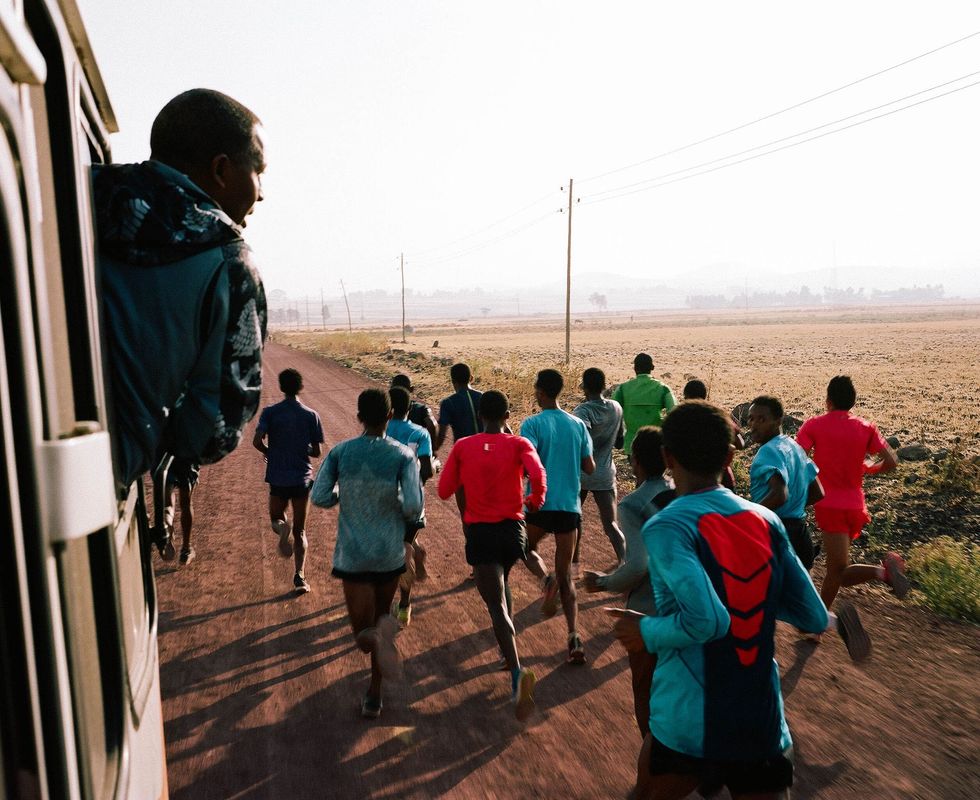 Halverwege een trainingsloop van 35 kilometer in de buitenwijken van Addis Abeba Ethiopi deelt coach Haji Adillo water uit aan zijn hardlopers Zulke lange runs spelen een belangrijk rol in de opbouw van het uithoudingsvermogen van de spieren en het hartenvaatstelsel dat nodig is om ultrasnelle marathons te kunnen lopen