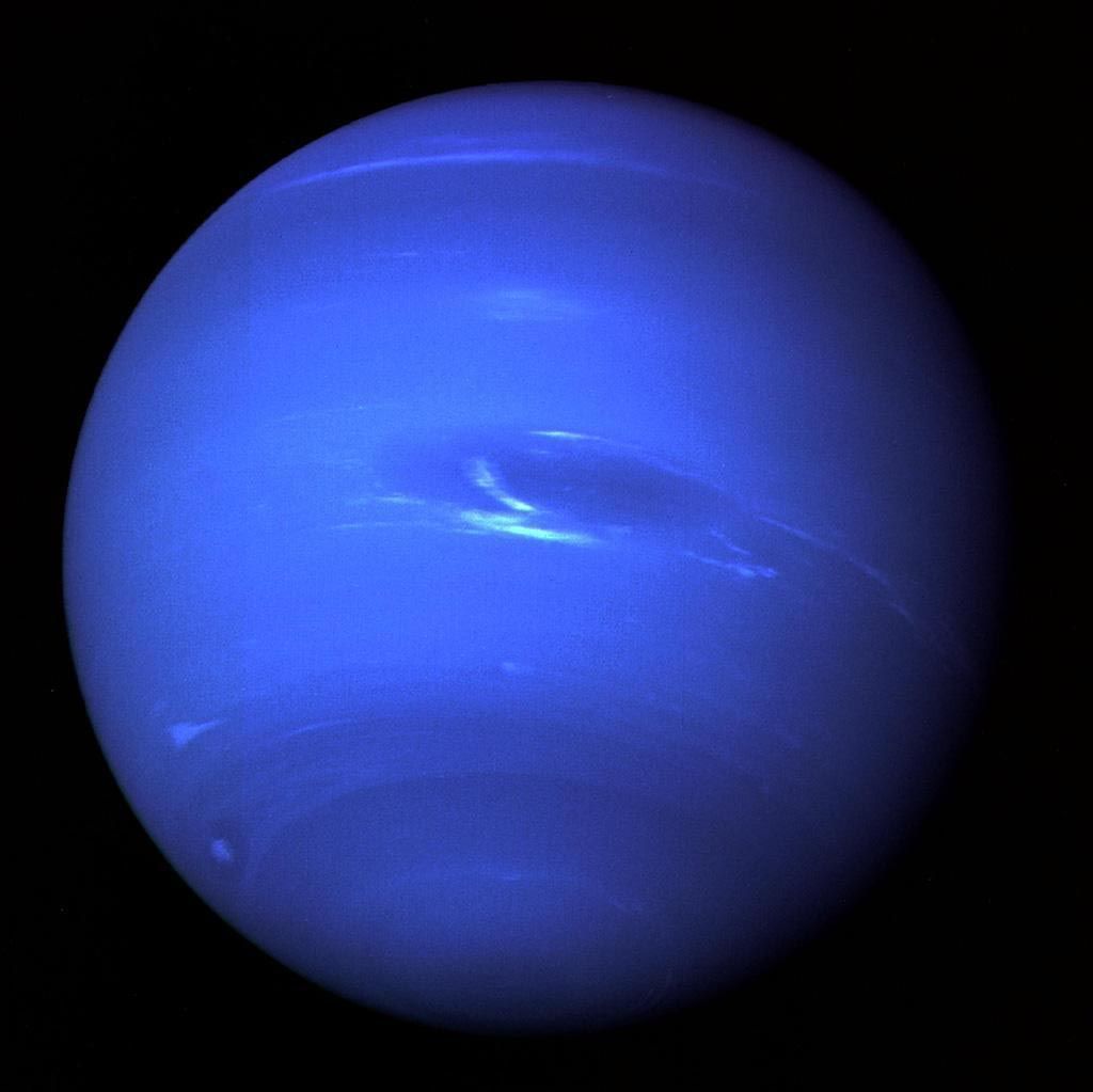 In deze opname van Voyager 2 die op een afstand van zeven miljoen kilometer van Neptunus werd gemaakt straalt de achtste en laatste planeet van het zonnestelsel in glorieus blauw De Grote Donkere Vlek op de planeet een storm is op zuiderbreedten te zien