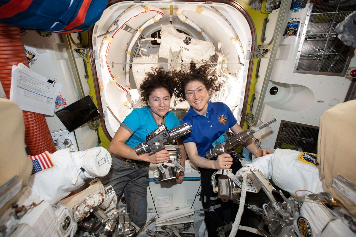 NASAastronauten Jessica Meir links en Christina Koch poseren op 18 oktober in de Questluchtsluis aan boord van het International Space Station terwijl ze hun ruimtepakken en instrumenten gereedmaken voor hun historische ruimtewandeling