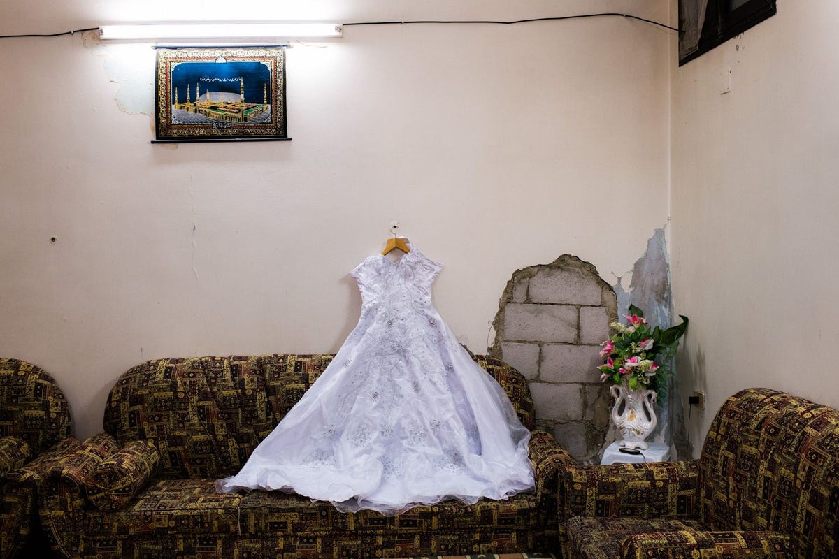 In het huis van haar grootouders in Baba Amr een kapotgeschoten wijk in Homs de op twee na grootste stad van Syri is de trouwjurk van de 15jarige Farida Fetrawi uitgestald naast een pas gerepareerd gat in de muur dat tijdens de zwaarste gevechten van de burgeroorlog werd gebruikt om veilig van de ene naar de andere kamer te kunnen kruipen