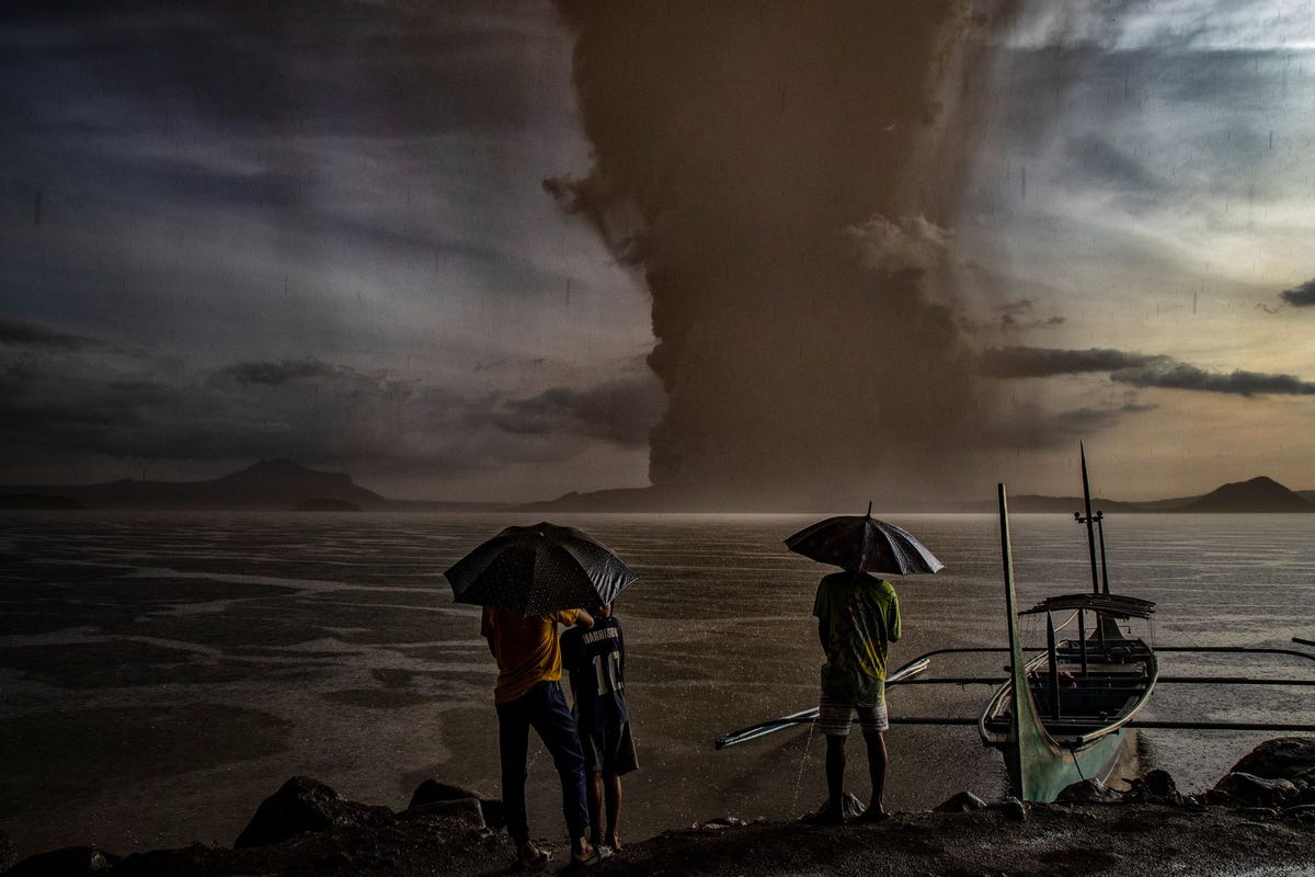 Een grote wolk as rijst op boven het Meer van Taal nadat de gelijknamige vulkaan op 12 januari tot uitbarsting is gekomen De voortgaande eruptie heeft de wijde omgeving met as bedekt en heeft geleid tot de evacuatie van bewoners het sluiten van scholen en het annuleren van vluchten