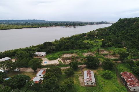 Van bovenaf ziet de site naast de Panganirivier in Tanzaniaeruit als veld met onbeduidende lege visvijvers Op de achtergrond doemt de Indische Oceaan op