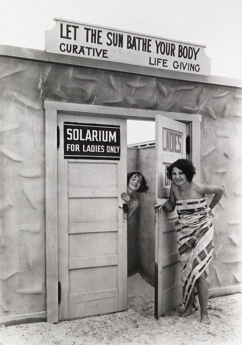 Vrouwen poseren voor een zonnestudio op het strand van St Petersburg Florida Zonnebaden was populair in 1929  het kraampje prijst het aan als verbeterend en leven schenkend