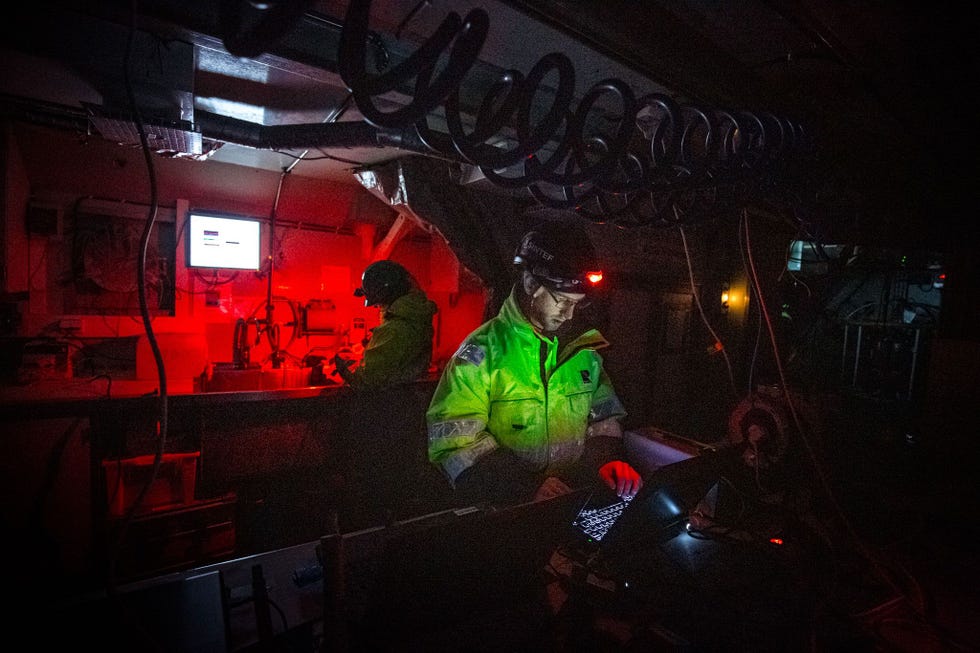 Emlyn Davies bekijkt de gegevens die op een reeks laptops aan boord van het onderzoeksschip Helmer Hanssen binnenkomen De laptops zijn verbonden met sensoren die de hoeveelheid licht en fytoplankton in het zeewater rond het schip registreren Davies werkt bij het schijnsel van zijn hoofdlamp omdat zelfs het zwakste kunstlicht de experimenten zou kunnen verstoren