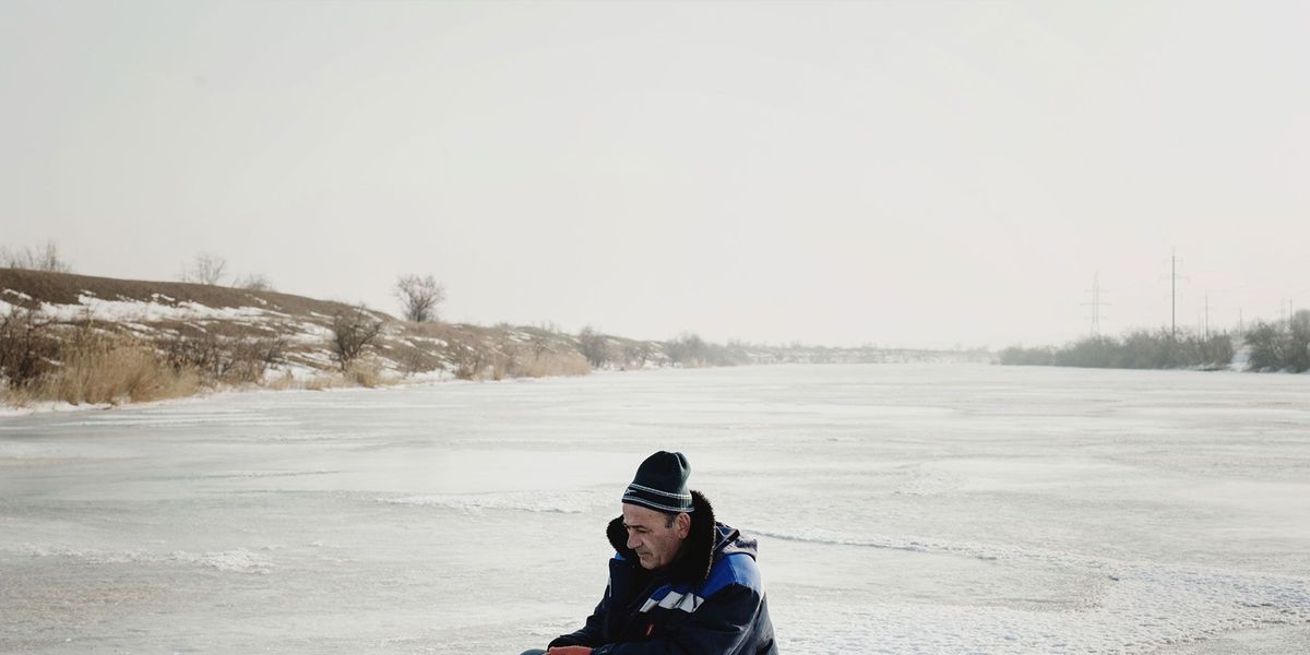 Op de bevroren rivier de Jalpuch vist een ijsvisser s winters door een klein gat in het ijs