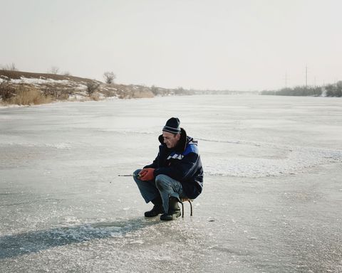 Op de bevroren rivier de Jalpuch vist een ijsvisser s winters door een klein gat in het ijs