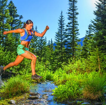 Hispanic woman jumping over stream hispanic woman jumping over stream