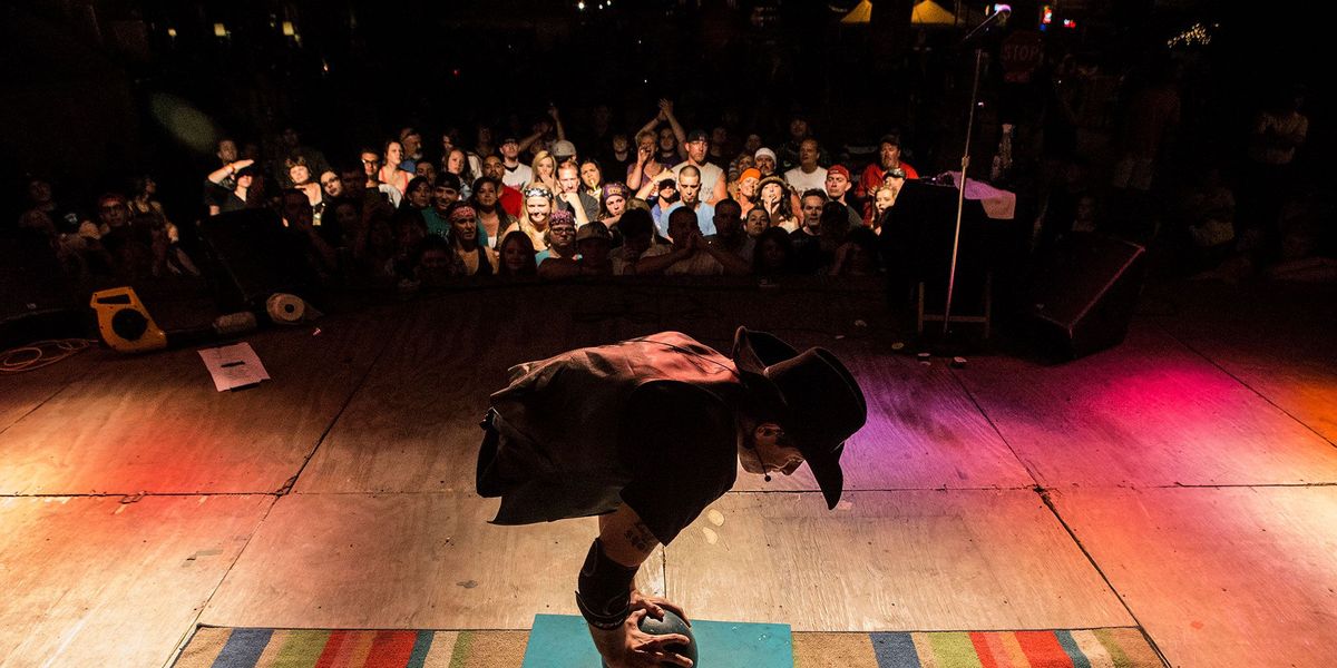 Aaron Wollin met de artiestennaam Short E Dangerously onderhoudt zijn publiek met een balanceeract op losse bowlingballen onderdeel van de rondreizende Hellzapoppin Circus Sideshow