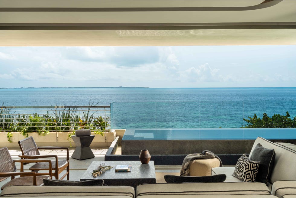 a patio with a table and chairs overlooking a body of water