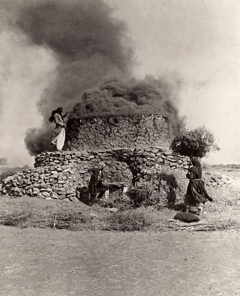 In de buurt van Homs in Syri dragen de vrouwen van een dorp struiken naar een rokende kalkoven waarin brandstof wordt vervaardigd 1913