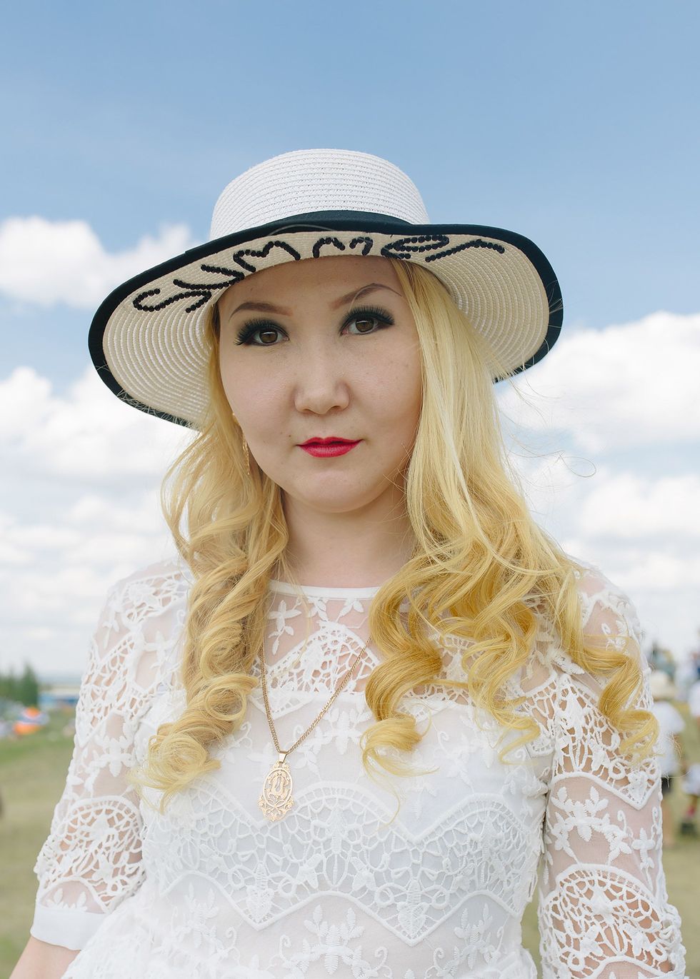 Een Jakoetische vrouw draagt een hoed met daarop het Engelse woord summer Hoewel Jakoeti beroemd is om zijn ongekend strenge winters ontvangt de regio in de zomer net zoveel of zelfs meer toeristen