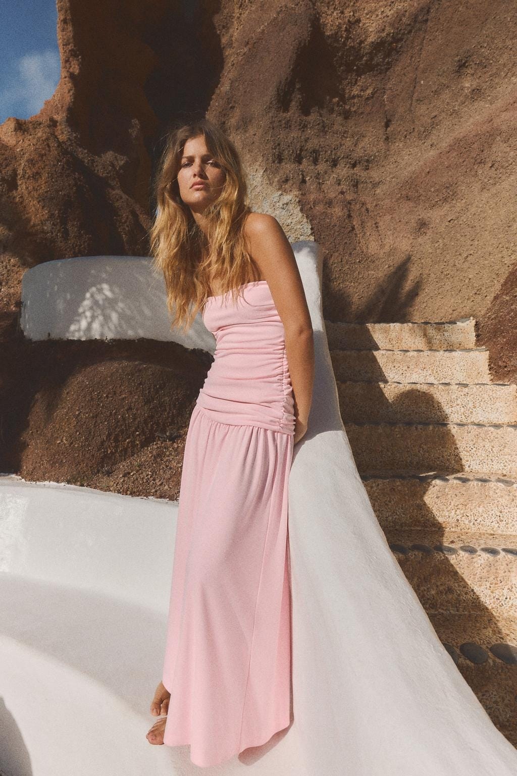 portrait of a woman in a pink dress against a textured background