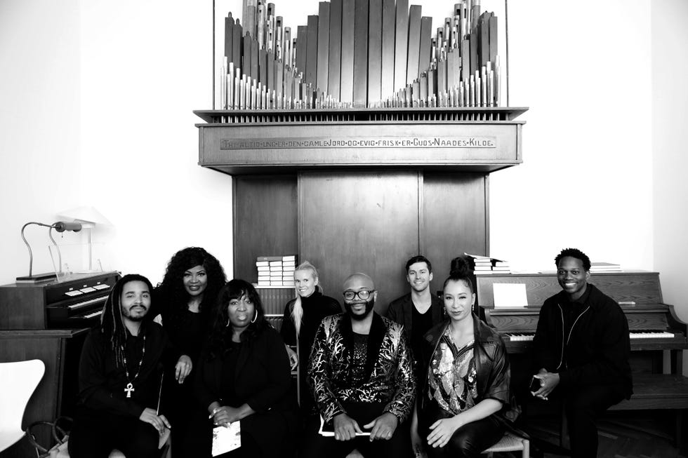 a band of singers next to an organ