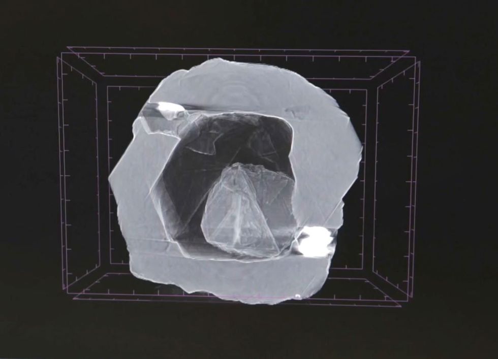 Deze rntgenopname van het matroesjkadiamantje toont het piepkleine edelsteentje in de lege holte binnenin een grotere diamant Zon holte kan niet bestaan onder de enorme druk die diep onder het aardoppervlak heerst dus denken onderzoekers dat de lege ruimte ooit moet zijn gevuld met andere mineralen