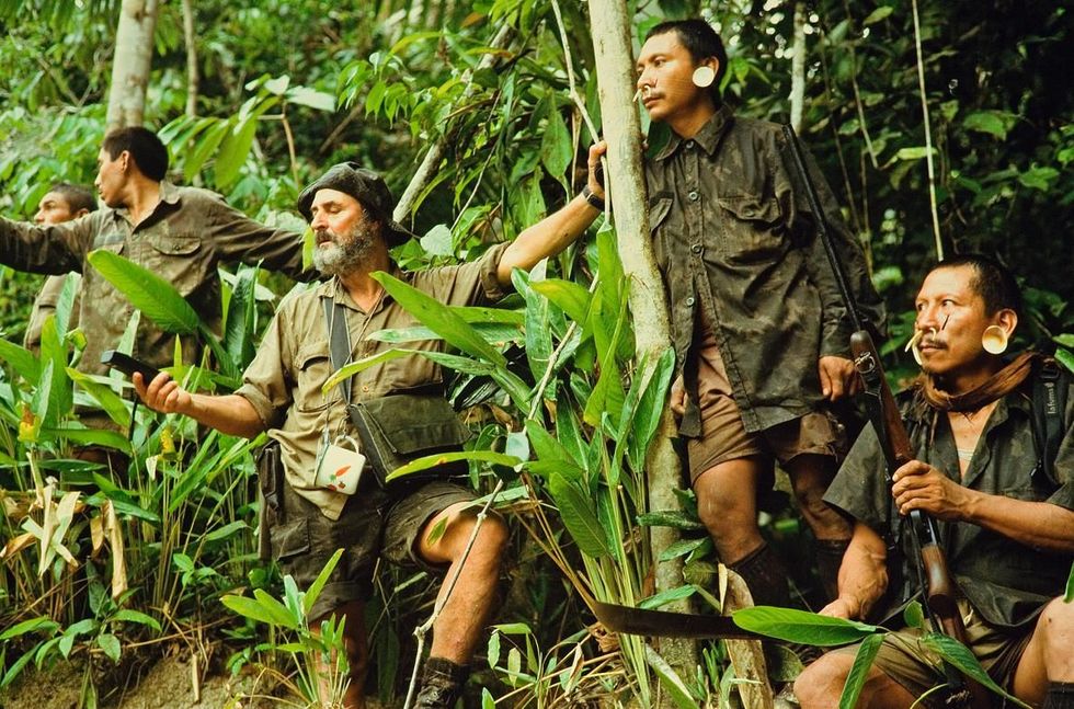Tepi leunt tegen een boom terwijl expeditieleider Sydney Possuele zijn GPS checkt Tepi was een van Possuelos meest gewaardeerde scouts