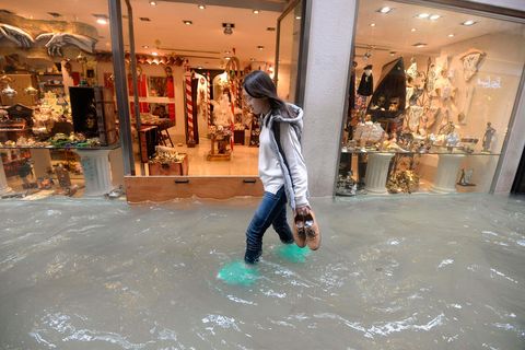 Een vrouw loopt door een ondergelopen straat in Veneti Volgens het stadsbestuur stond ongeveer 75 van de stad aan de lagune onder water tijdens de overstromingen in 2018