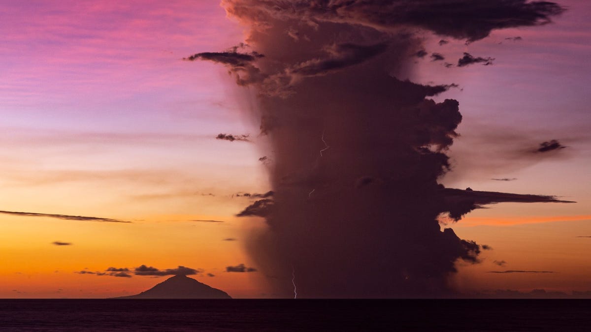 Bliksemstralen in een vulkaanwolk die Anak Krakatau aan het zicht onttrekt tijdens een uitbarsting in januari 2019 Deze foto is twee weken na de instorting van een flank van de vulkaan gemaakt De instorting veroorzaakte een tsunami die insloeg op nabijgelegen kusten en luidde het begin in van een vulkanische onweersbui die zes dagen zou duren