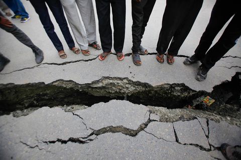 Wegen in en rond Kathmandu zijn opengespleten als gevolg van de aardbeving en haar naschokken Hier inspecteren Nepalezen een scheur die door de aardbeving veel breder en daardoor gevaarlijk is geworden