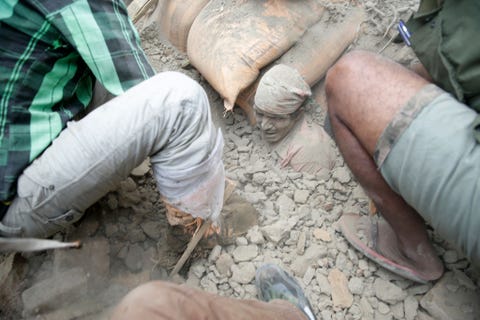 People tried to free this man in Kathmandu Saturday even as aftershocks continued shaking the area