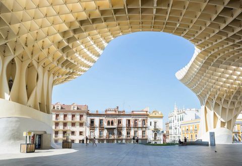 De moderne lijnen van de Metropol Parasol omlijsten de historische gebouwen in de Spaanse stad Sevilla en zorgen zo voor een contrast tussen nieuw en oud Metropol Parasol ook wel Las Setas de Paddenstoelen genoemd is een ontwerp van de Duitse architect Jrgen Mayer en is het grootste houten bouwwerk ter wereld