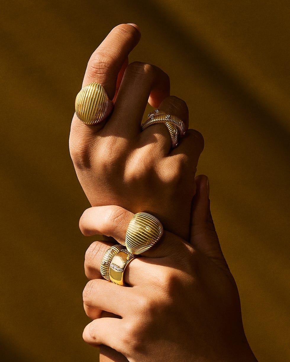 a display of multiple gold rings worn on hands