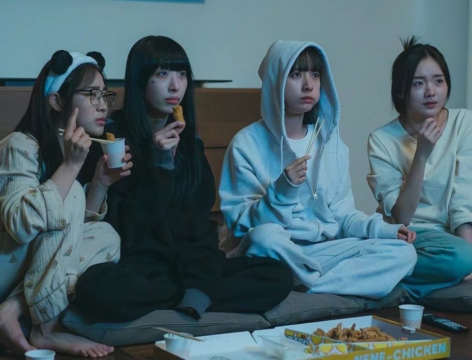 a group of women sitting on a couch eating food
