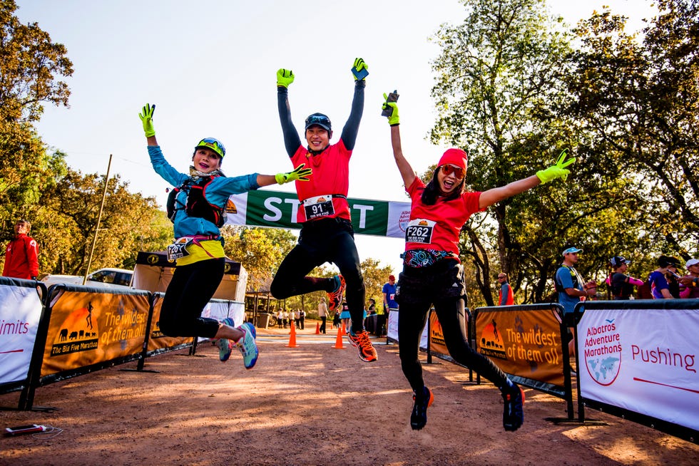 three runners celebrating at the start line of a marathon