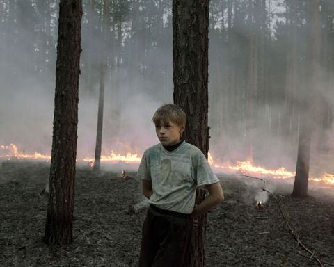 Een jongetje staat bij een tegenvuur dat de inwoners in 2016 aanlegden om een bosbrand onder controle te houden