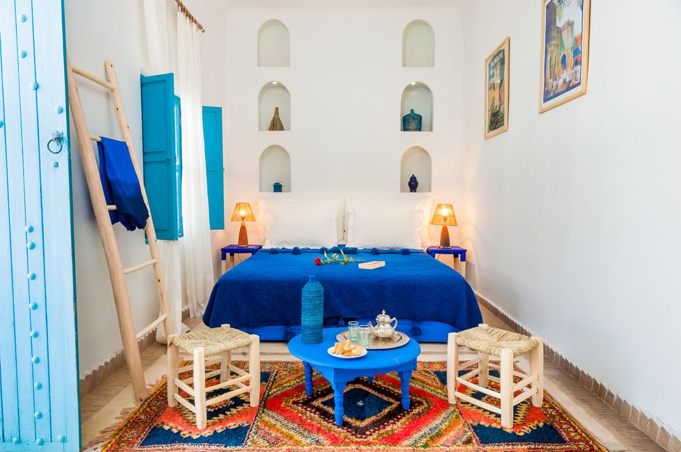 a room with a bed and a table with a blue blanket