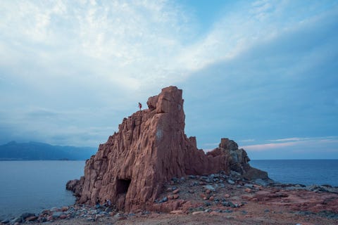 SARDINI ITALI  De Rocce Rosse de beroemde rotsen van rode porfier aan de Ogliastrakust van Sardini vormen een onweerstaanbare springplank voor ervaren rotsduikers Fotograaf Andrea Frazzetta beschrijft de rotsen als vurige architectonische details die door de tijd zijn ontworpen