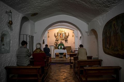 In de Nuestra Seora de Gracia een ondergrondse katholieke kerk in Guadix gaat de priester voor in de mis In de kerk uit de zestiende eeuw staat een afbeelding van de Schutsvrouwe van de Grotten