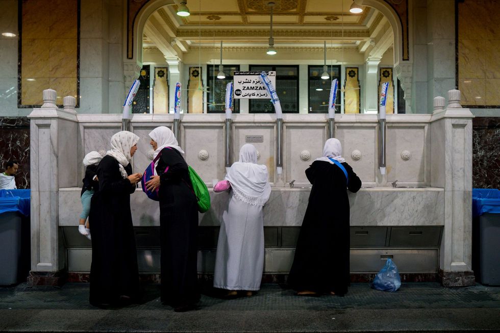 Vrouwen halen water uit de Zamzambron in de Grote Moskee van Mekka Volgens de overlevering werd de bron door God geslagen om de dorst van Abrahams familie in Mekka te lessen Pelgrims vullen flessen met Zamzamwater om het voor hun dierbaren mee naar huis te nemen