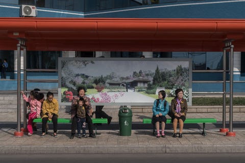 Op een foto die op zondag 9 april 2017 werd genomen wachten passagiers bij een bushalte in Pyongyang