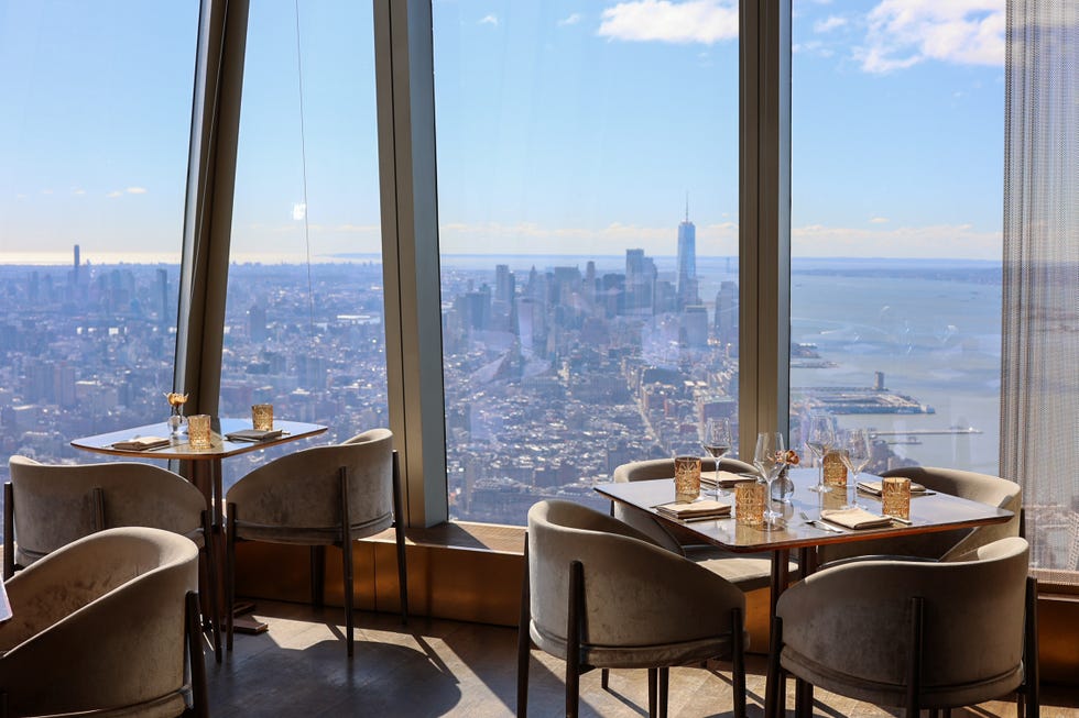 a room with tables and chairs with a view of a city