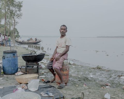 De picknickfeesten brengen vaak hun eigen koks mee om vers voedsel te bereiden Hier zit een kok vlakbij zijn werkplek bij de Ichamati Rivier in West Bengal
