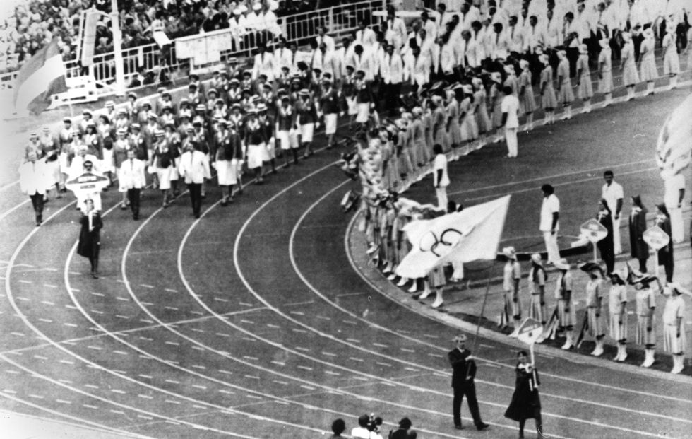 Dick Palmer secretaris van het Britse olympische team vooraan rechts draagt de olympische vlag Hij vertegenwoordigt de British Olympic Association tijdens de parade van de openingsceremonie van de Olympische Zomerspelen van 1980 in Moskou De Britse atleten waren opvallend afwezig Zij boycotten de openingsceremonie vanwege de invasie van Afghanistan door de SovjetUnie
