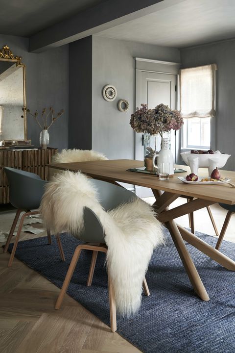dining room with blue rug and wooden table, blue chairs and sheep skin rug, gray paint