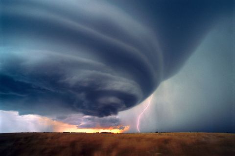 Tegen zonsondergang slaat een eenzame bliksemschicht in op de grond onder een gesoleerde zware onweerswolk een supercel Supercellen zijn de gevaarlijkste en meest gebruikelijke van de twee soorten onweersbuien die tornados kunnen voortbrengen