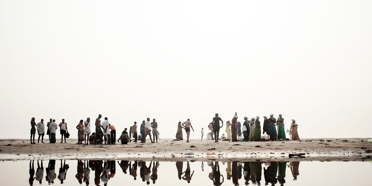 Hindoepelgrims aan de oever van de Ganges maken zich klaar om in de heilige rivier te baden