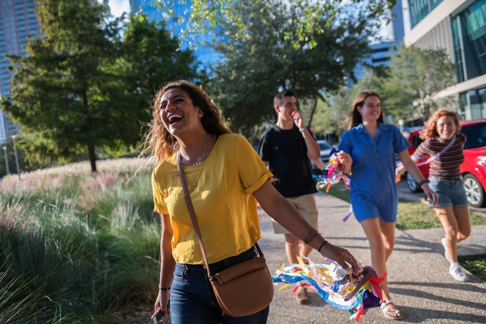 Hannah Ajrami studente aan de University of Houston lacht met vriendinnen op de campus