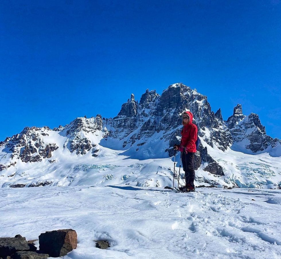 person standing on a snowy landscape with mountainous background