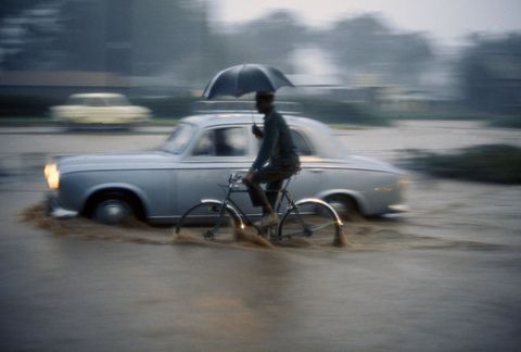 Een man rijdt door 10 centimeter regenwater in de binnenstad van Nairobi in Kenia Deze foto komt uit een editie van National Geographic uit 1969