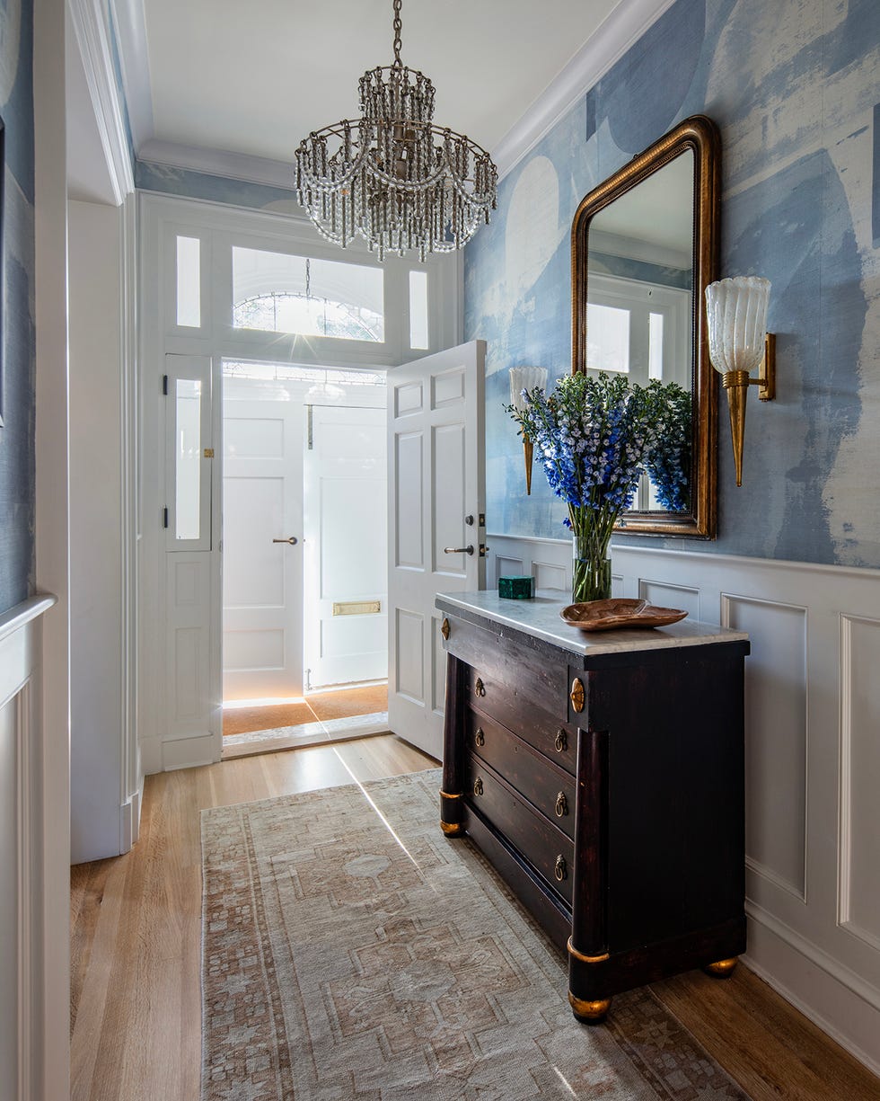 entryway featuring a dark wooden console floral arrangement and decorative mirror