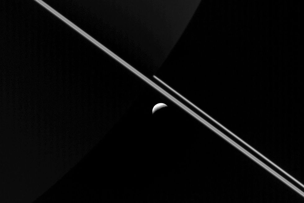 Van veraf lijkt Enceladus te rond Saturnus beroemde ringen te zweven