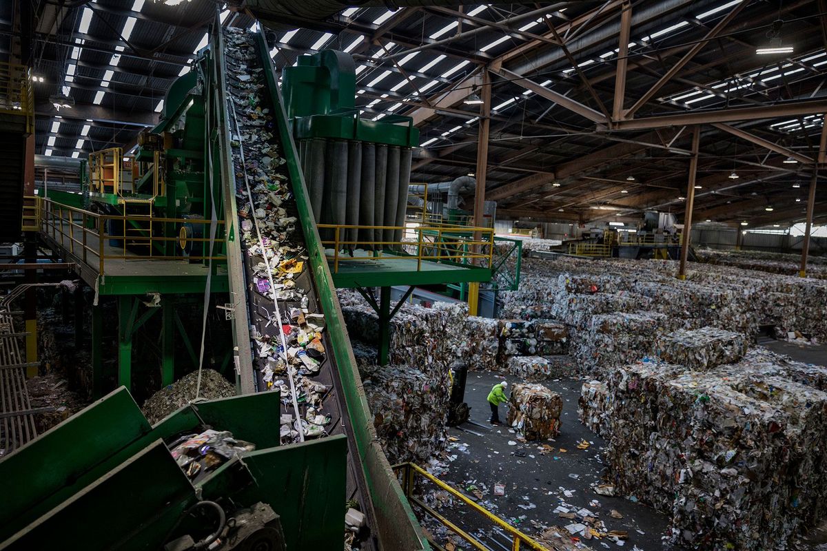 In een recyclingcentrale in San Francisco wordt gemengd plastic via een lopende band naar een sorteermachine gevoerd