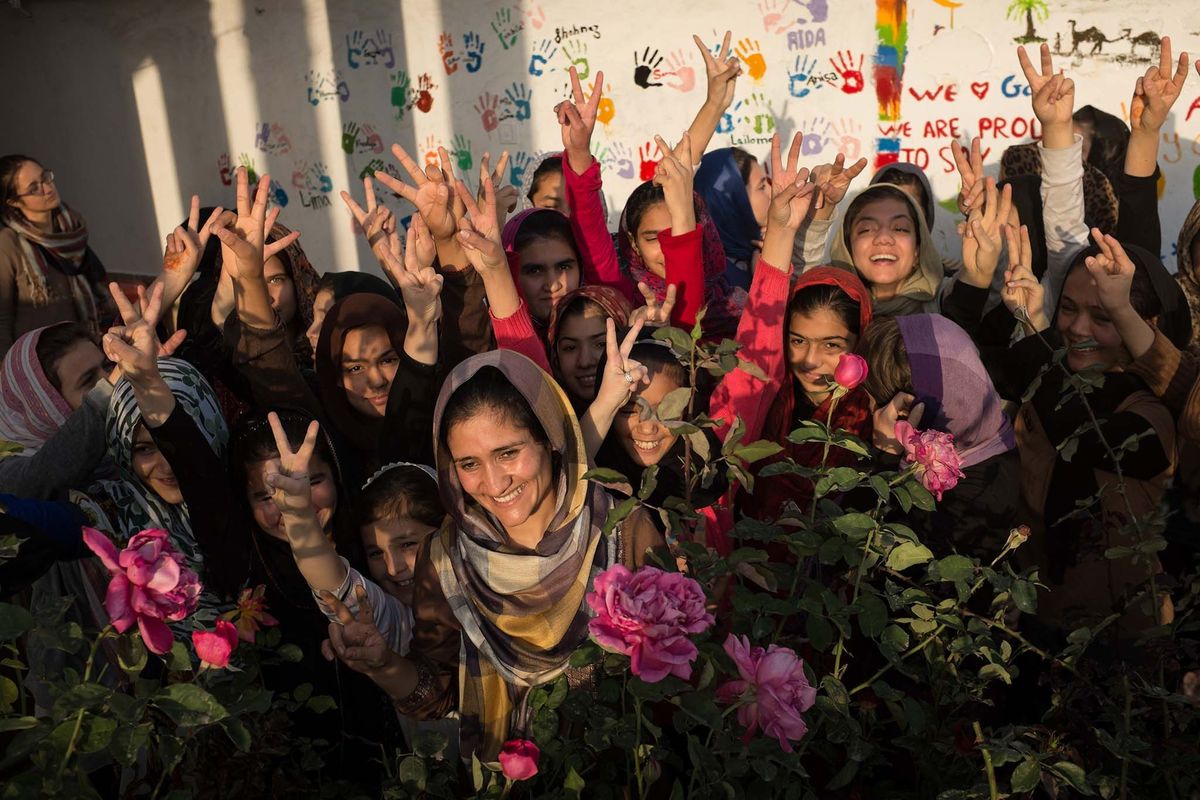 Shabana BasijRasikh National Geographic Explorer voor 2014 en medeoprichterdirecteur van de School of Leadership Afghanistan SOLA poseert met leerlingen in de tuin van haar kostschool voor Afghaanse meisjes
