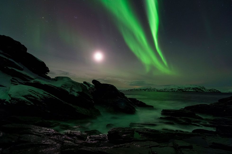 Het noorderlicht werpt een spookachtig groen schijnsel over de Finnmark in Noorwegen