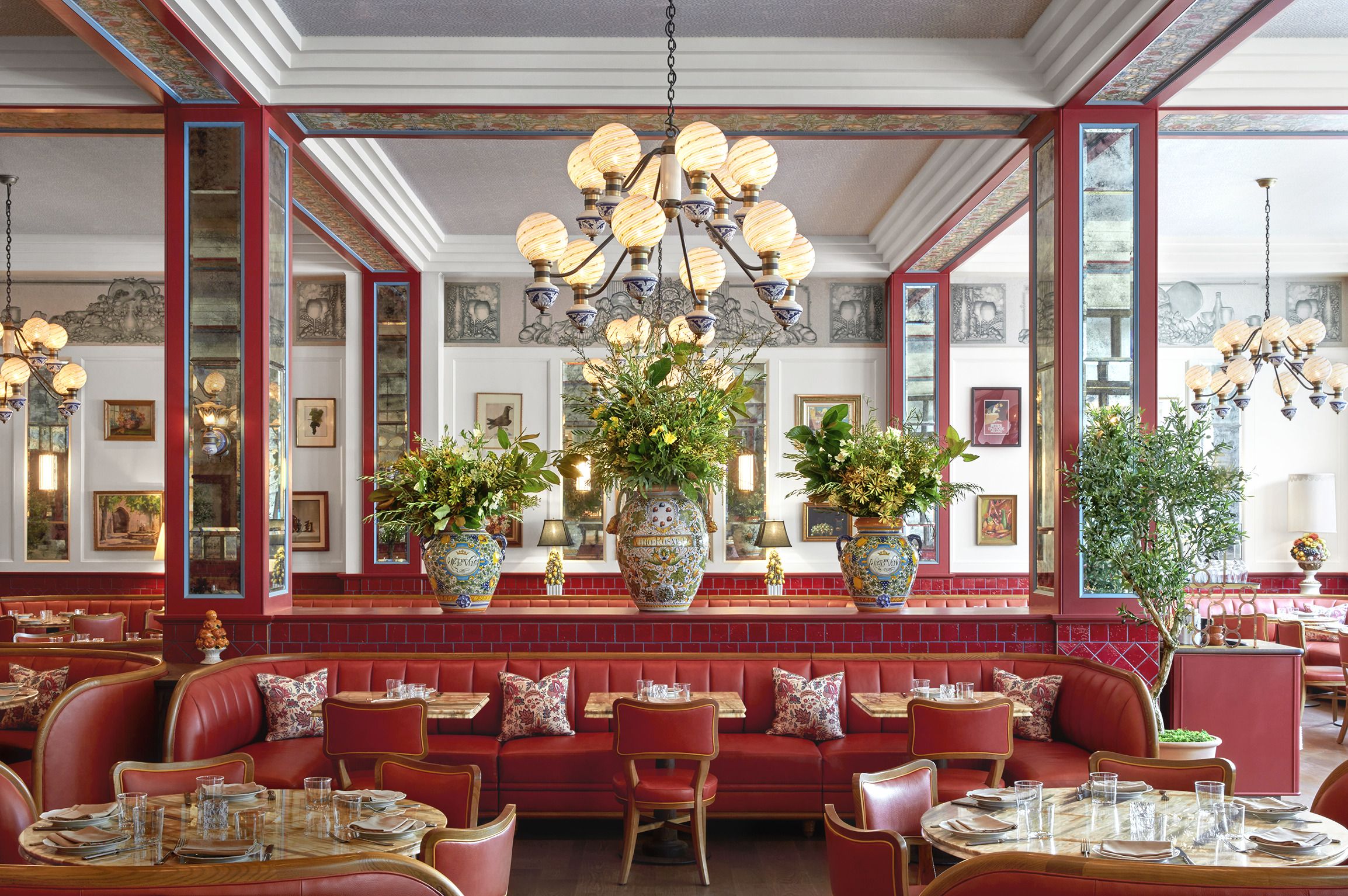 A List 2022 - ELLE DECOR interior of restaurant all in red with a large bouquet of flowers between two glass openings